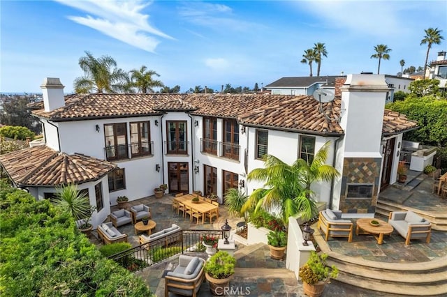 212 John St, Manhattan Beach, CA 90266 - rear view of house featuring a balcony, outdoor lounge area, a chimney, a patio area, and a tiled roof