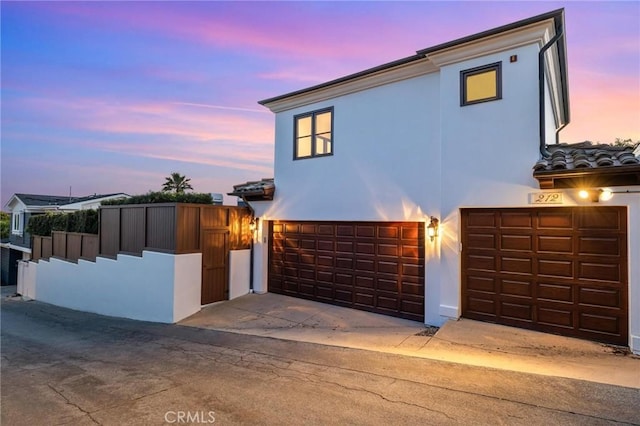 212 John St, Manhattan Beach, CA 90266 - view of front facade with an attached garage, fence, and stucco siding