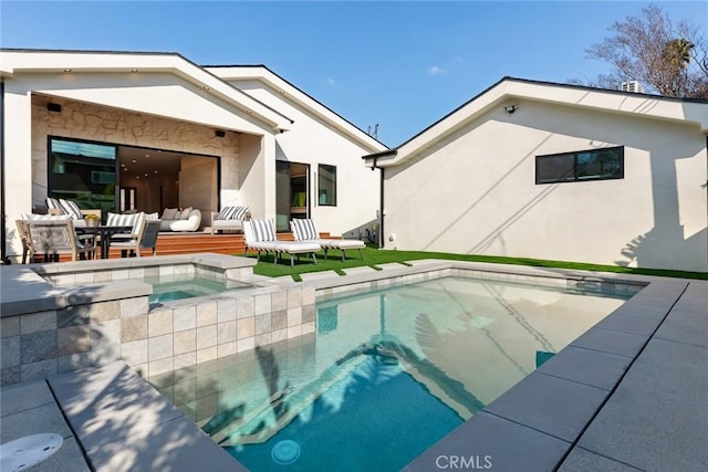 outdoor pool with an in ground hot tub, outdoor lounge area, and a patio area