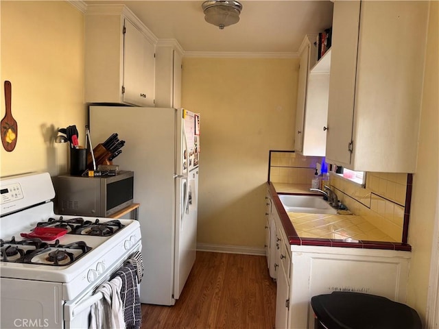 kitchen with white appliances, tile counters, sink, and white cabinets