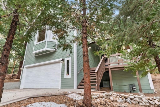 exterior space featuring a garage, a deck, and central air condition unit