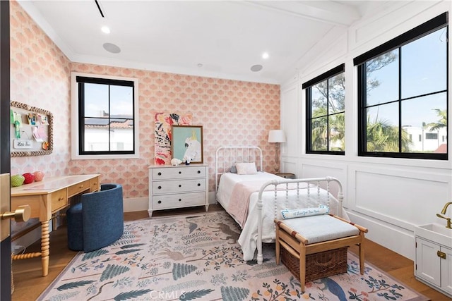 bedroom featuring light wood-style floors, multiple windows, and wallpapered walls