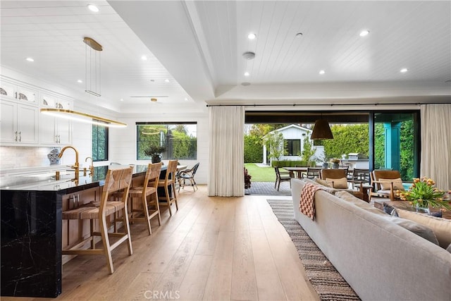 living room featuring light wood-type flooring, a healthy amount of sunlight, and recessed lighting