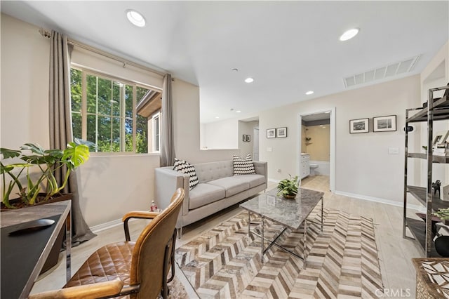 living room with light wood finished floors, baseboards, visible vents, and recessed lighting