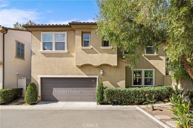 multi unit property featuring driveway, a tiled roof, an attached garage, and stucco siding