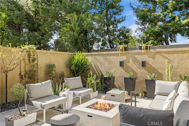 view of patio featuring a fenced backyard and an outdoor living space with a fire pit