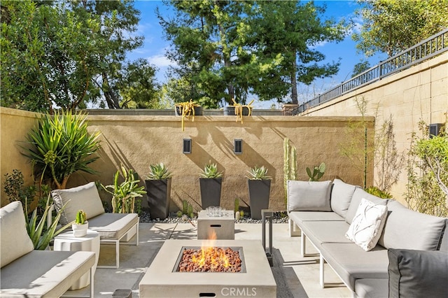 view of patio / terrace with an outdoor living space with a fire pit and a fenced backyard