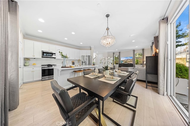 dining area featuring crown molding, recessed lighting, a notable chandelier, and light wood-style floors