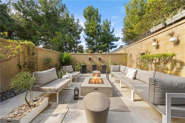 view of patio / terrace with a fenced backyard and an outdoor living space with a fire pit