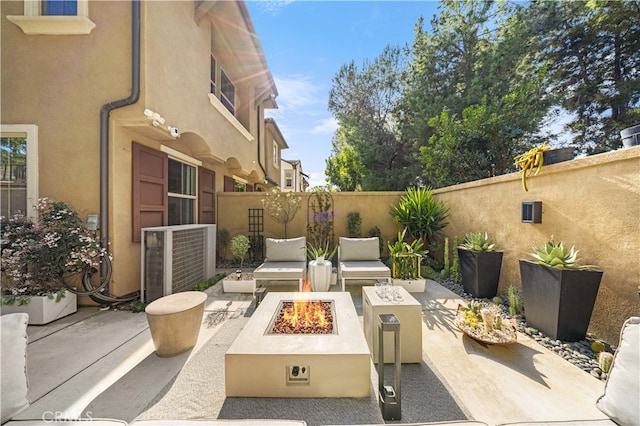 view of patio / terrace with cooling unit, an outdoor living space with a fire pit, and a fenced backyard