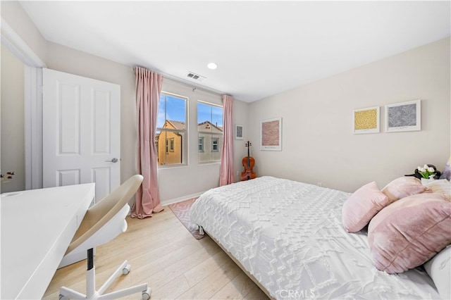 bedroom with light wood finished floors and visible vents