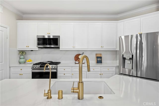 kitchen featuring tasteful backsplash, white cabinets, stainless steel appliances, crown molding, and a sink