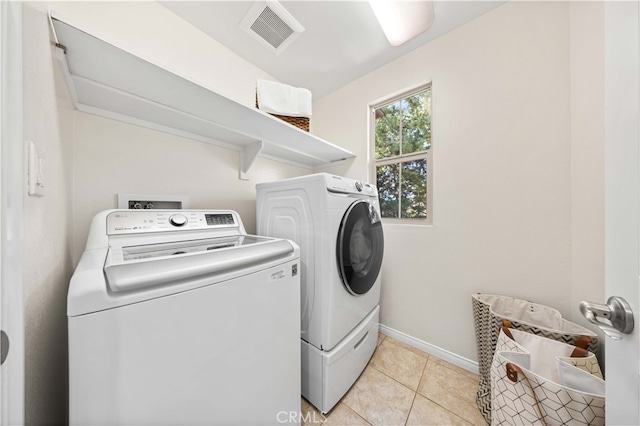 laundry area with laundry area, light tile patterned floors, baseboards, visible vents, and separate washer and dryer