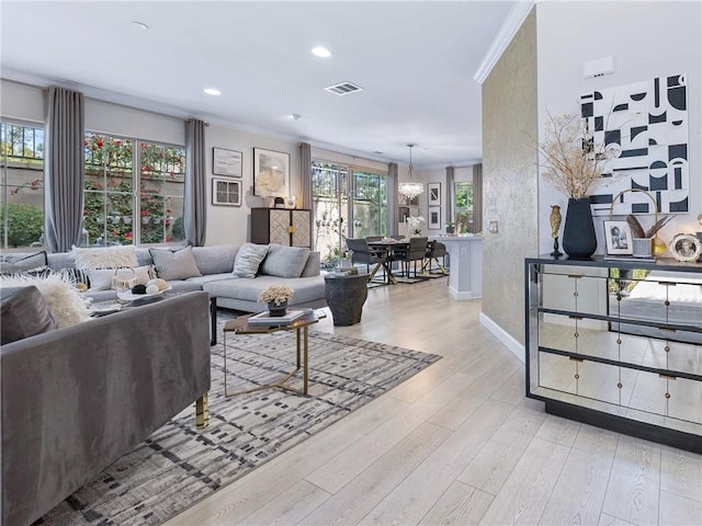 living room with light wood finished floors, visible vents, crown molding, baseboards, and recessed lighting