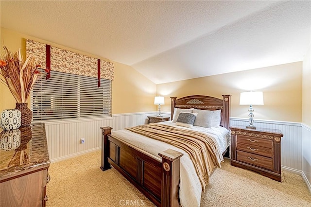 bedroom with lofted ceiling, light carpet, and a textured ceiling