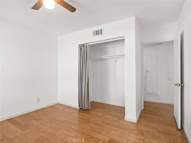 unfurnished bedroom featuring ceiling fan, a closet, and light wood-type flooring