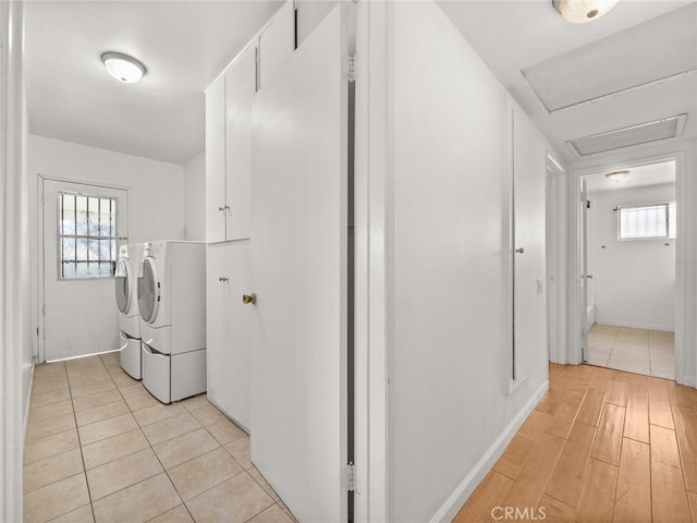 washroom featuring cabinets, independent washer and dryer, and light hardwood / wood-style flooring