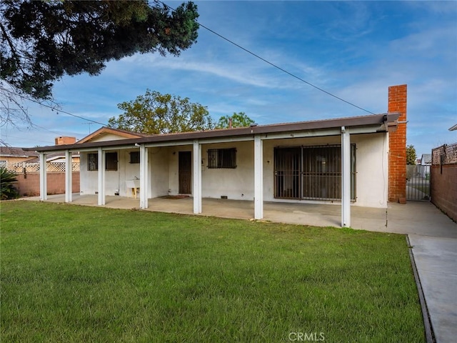 rear view of property with a yard and a patio