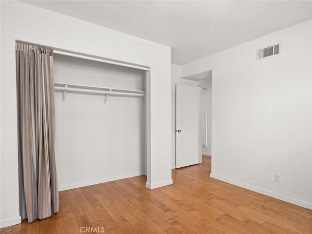 unfurnished bedroom featuring light hardwood / wood-style floors and a closet