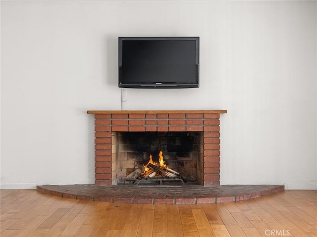 interior details featuring hardwood / wood-style flooring and a brick fireplace