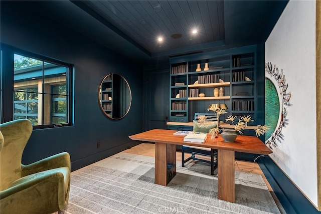 office space featuring wood ceiling, a raised ceiling, and built in shelves