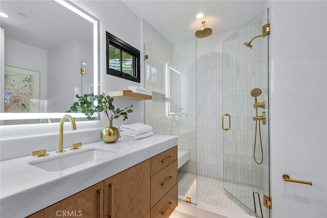 bathroom featuring a shower with door and vanity