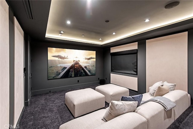 carpeted cinema with a raised ceiling