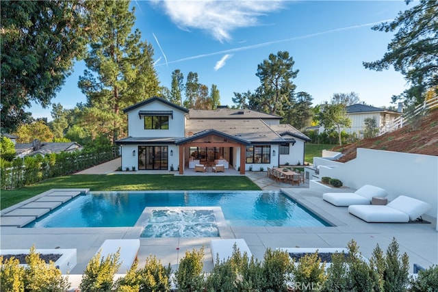 rear view of property featuring a fenced in pool, a yard, and a patio area