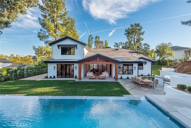 rear view of house featuring outdoor lounge area, a lawn, and a patio area