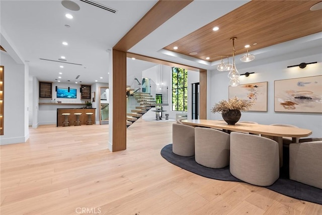 dining room with light hardwood / wood-style flooring and a tray ceiling