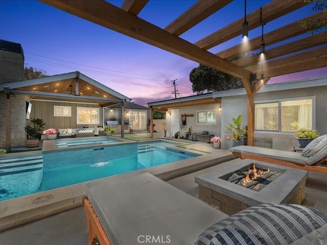 pool at dusk featuring an in ground hot tub, an outdoor fire pit, and a patio