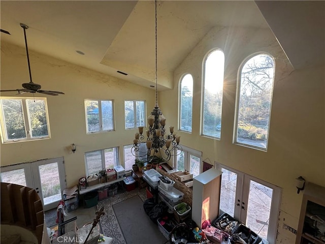 living room with a wealth of natural light, high vaulted ceiling, and french doors