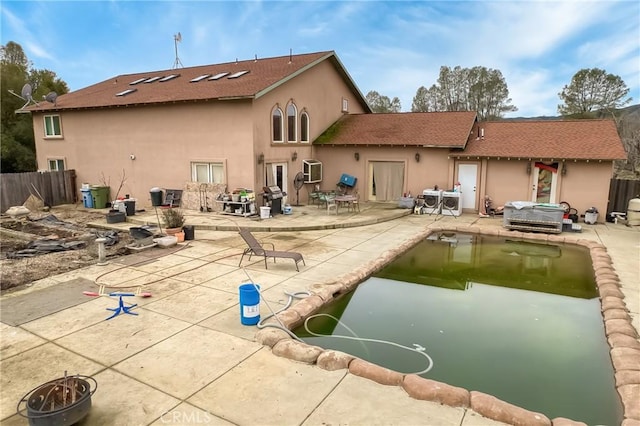 back of property featuring a jacuzzi and a patio area