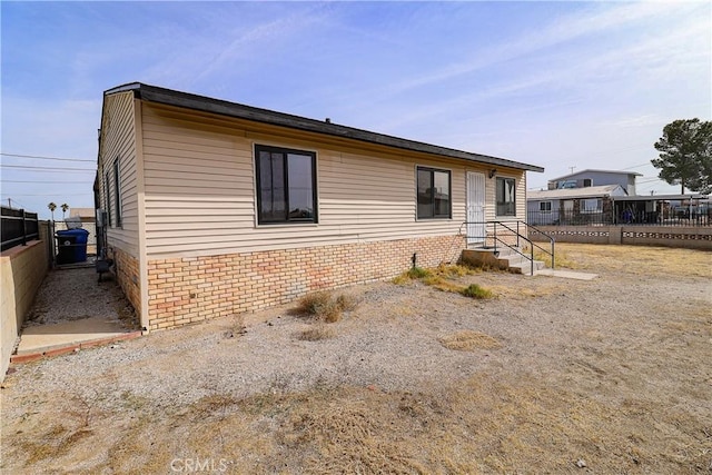 manufactured / mobile home with fence and brick siding