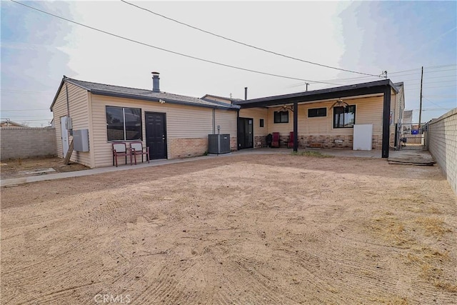 back of property featuring a fenced backyard and central AC unit