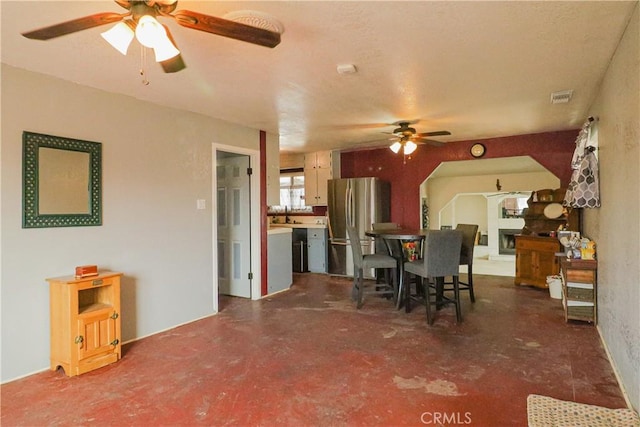 dining space featuring visible vents, concrete flooring, and a ceiling fan