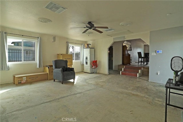 living area featuring ceiling fan, unfinished concrete flooring, and visible vents