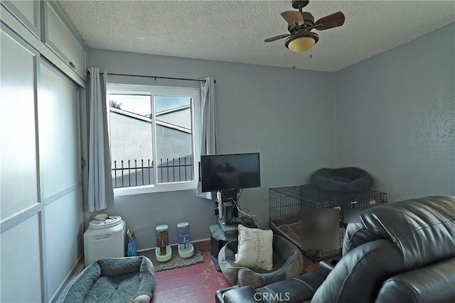 interior space featuring a textured ceiling, baseboards, and a ceiling fan