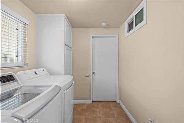 laundry area featuring light tile patterned flooring, cabinets, and washer and dryer