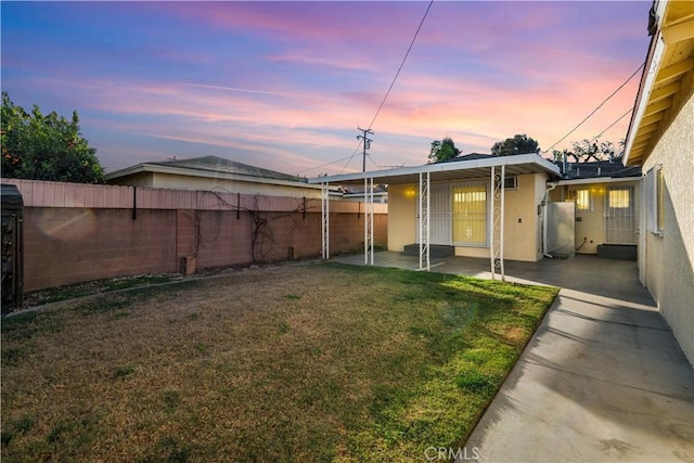 yard at dusk featuring a patio