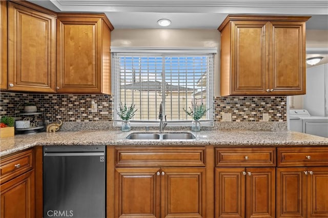 kitchen with sink, stainless steel dishwasher, light stone countertops, washing machine and dryer, and decorative backsplash