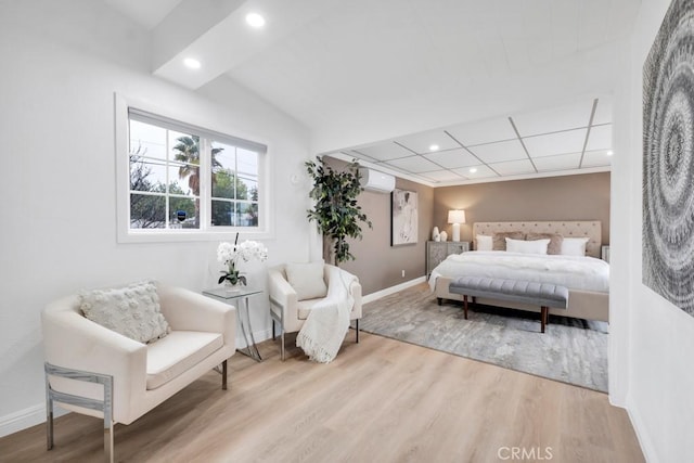 bedroom with a wall mounted air conditioner and wood-type flooring