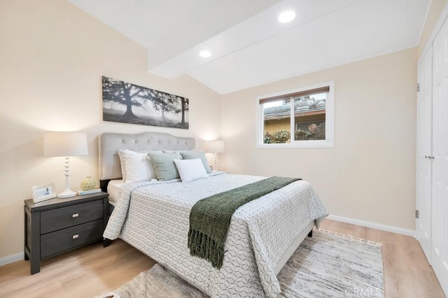 bedroom with light hardwood / wood-style flooring and vaulted ceiling with beams