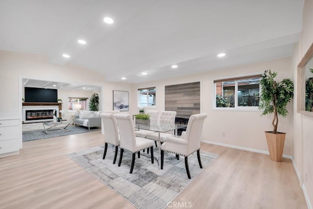 dining area with lofted ceiling and light wood-type flooring