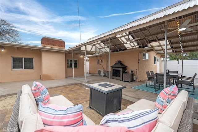 view of patio featuring ceiling fan and an outdoor living space with a fireplace