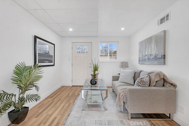 living room with a drop ceiling and hardwood / wood-style flooring