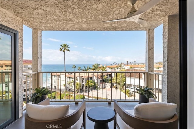 balcony featuring a water view and ceiling fan