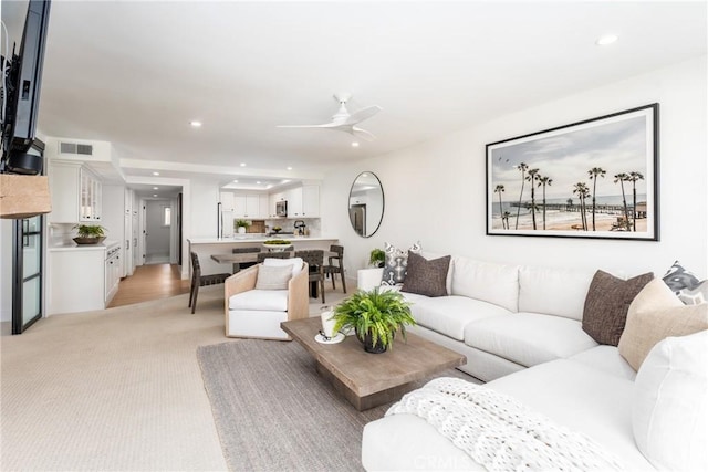 living room with ceiling fan and light colored carpet