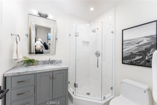 bathroom featuring walk in shower, vanity, and toilet