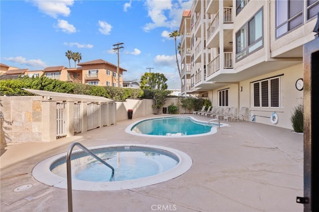 view of pool with a patio area and a hot tub